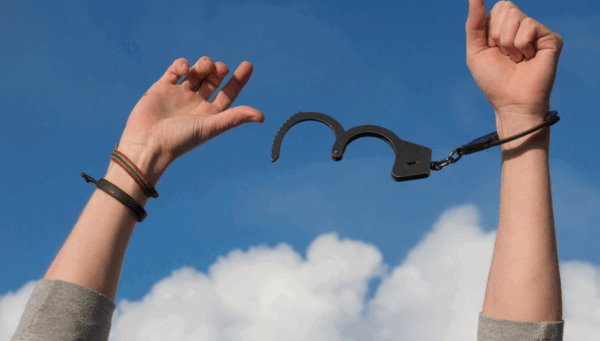 Woman’s hands breaking free of cuffs symbolizing bravery and living an authentic life.